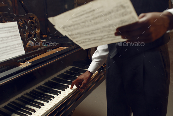 Black pianist with music notebook in his hands