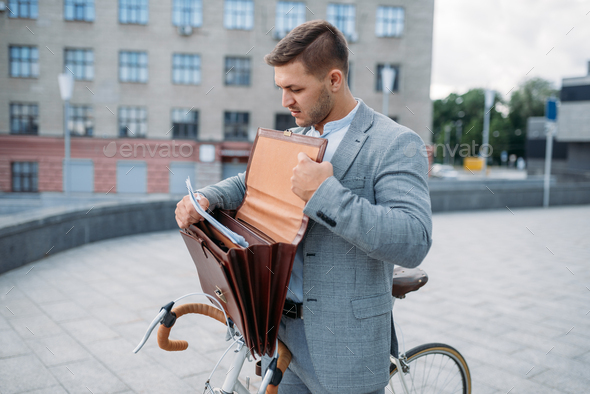 One businessman biking in suit with briefcase