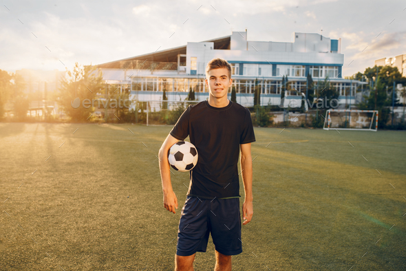 Male soccer player poses with ball in hands - Stock Photo - Images