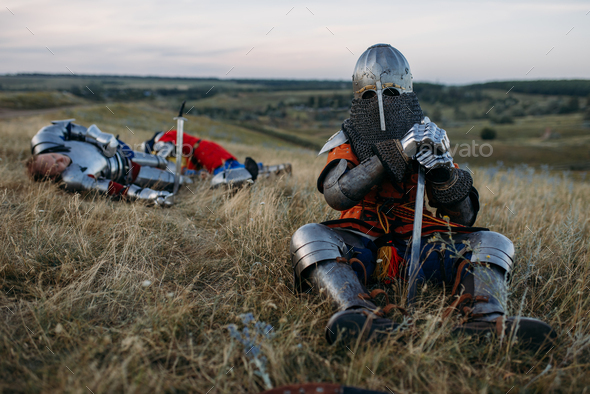 Medieval knight in armor sitting on the ground - Stock Photo - Images