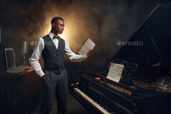 Ebony pianist with music notebook on the scene