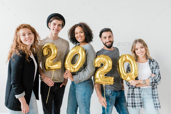 Group of multicultural friends holding golden balloons in form of numbers