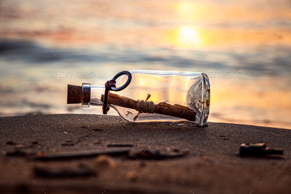 Message in the bottle against the Sun setting down - Stock Photo - Images