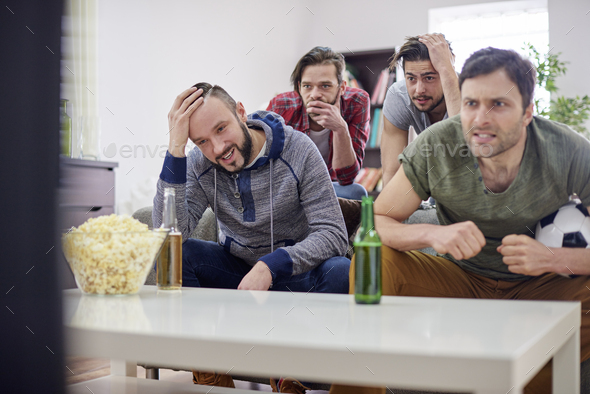 Disappointed men watching soccer match - Stock Photo - Images