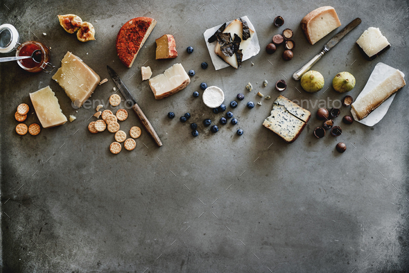 Variety of wine snacks, jam and cheeses over grey background - Stock Photo - Images