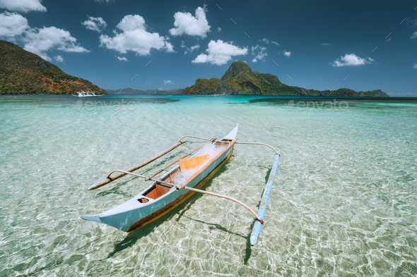Palawan, Philippines. Traditional small fishing banca boat in front of Cadlao Island in crystal - Stock Photo - Images