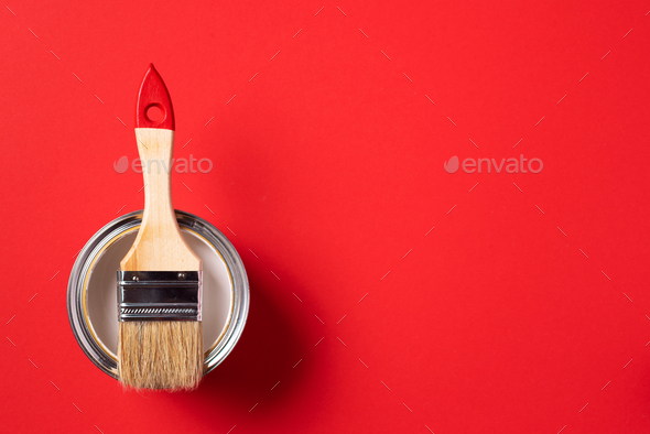 Brush and open paint can on trendy red background. Top view, copy space. Appartment renovation - Stock Photo - Images