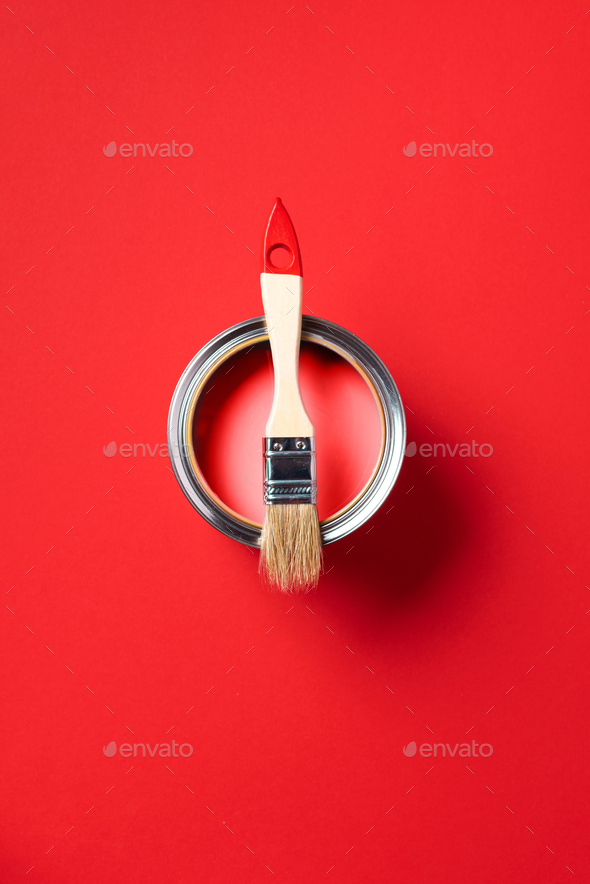 Brush and open paint can on trendy red background. Top view, copy space. Appartment renovation - Stock Photo - Images