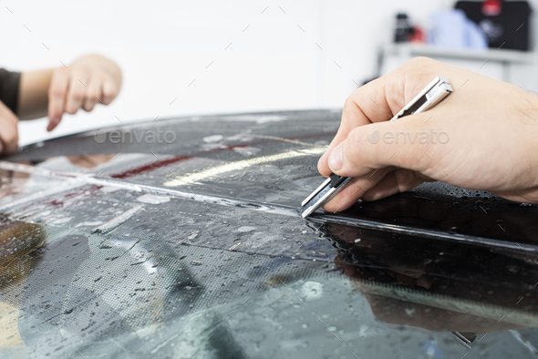 Applying a protective film with tools for work. Car detailing - Stock Photo - Images
