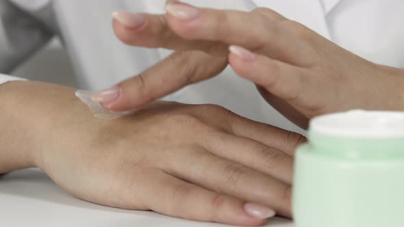 Cosmetic Dermatologist Testing Cream in Lab Spreading Plantbased Cream on Hand