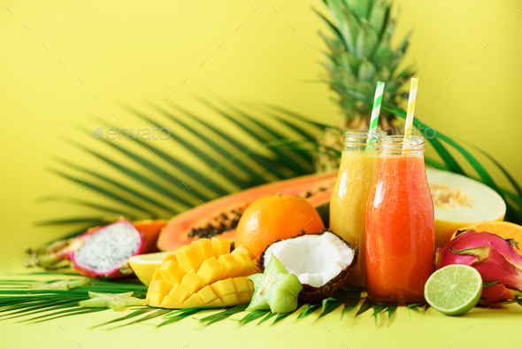 Juicy papaya and pineapple, mango, orange fruit smoothie in two jars on yellow background. Detox - Stock Photo - Images