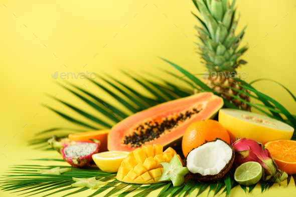 Assortment of exotic fruits on yellow background. Detox, vegan food, summer concept. Papaya, mango - Stock Photo - Images