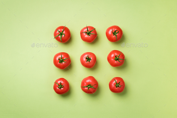 Creative pattern of red tomatos on green background. Top view. Copy space. Minimal design - Stock Photo - Images
