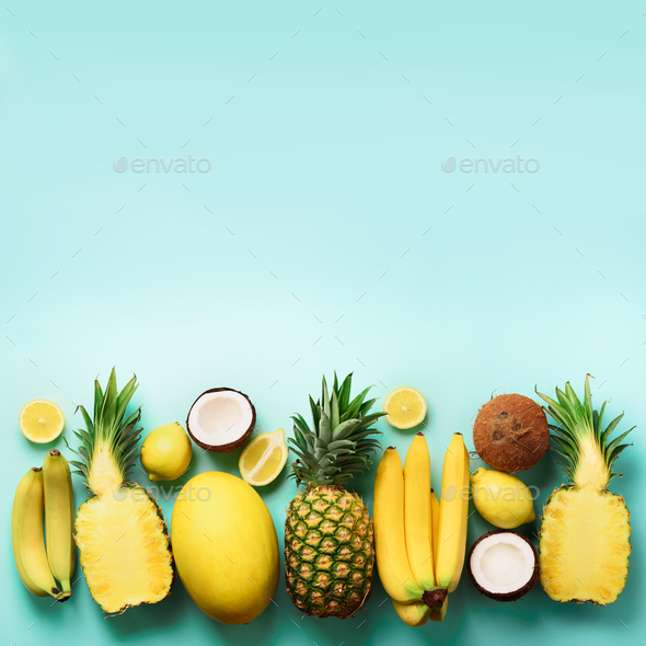 Fresh organic yellow fruits over blue background. Square crop. Monochrome concept with banana - Stock Photo - Images