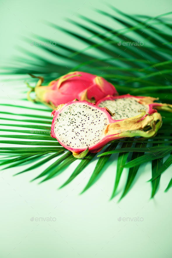 Pitahaya or dragon fruit over tropical green palm leaves on turquoise background. Copy space. Pop - Stock Photo - Images