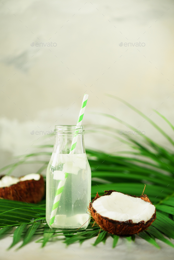 Bottle of coconut water and fresh ripe fruits on grey concrete background. Summer food concept - Stock Photo - Images