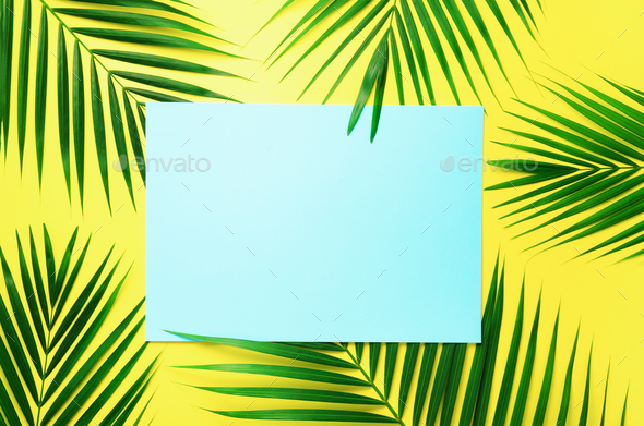 Tropical palm leaves on pastel yellow background with paper card note. Minimal summer concept - Stock Photo - Images