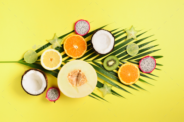 Exotic fruits and tropical palm leaves on pastel yellow background - papaya, mango, pineapple - Stock Photo - Images