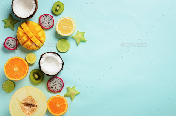 Exotic fruits on pastel blue background - papaya, mango, pineapple, banana, carambola, dragon fruit