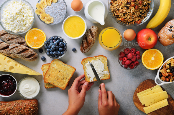 Female hands spreading butter on bread. Woman cooking breakfast. Healthy breakfast ingredients, food - Stock Photo - Images
