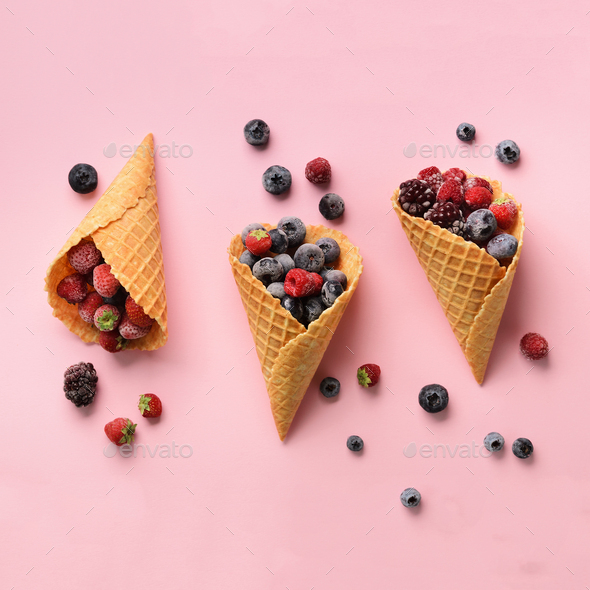 Frozen berries - strawberry, blueberry, blackberry, raspberry in waffle cones on pink background - Stock Photo - Images