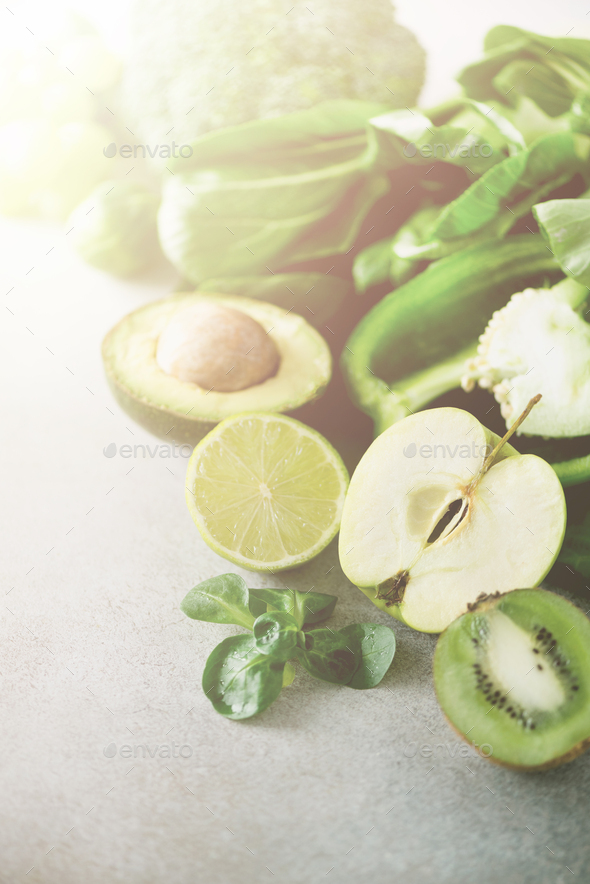 Green smoothie in glass jar with fresh organic green vegetables and fruits on grey background - Stock Photo - Images