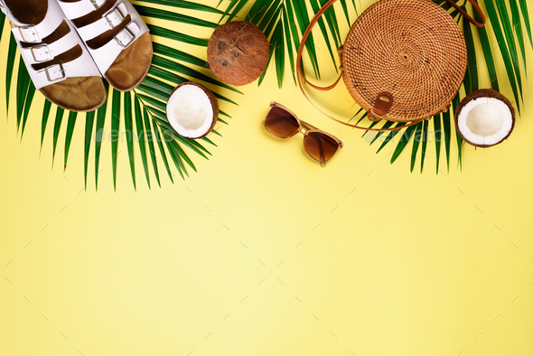 Round rattan bag, coconut, birkenstocks, palm branches, sunglasses on yellow background. Banner. Top - Stock Photo - Images