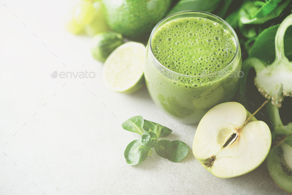 Glass with green health smoothie, kale leaves, lime, apple, kiwi, grapes, banana, avocado, lettuce - Stock Photo - Images