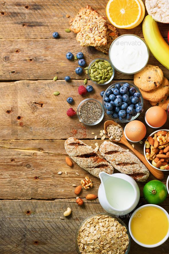 Healthy breakfast ingredients, food frame. Granola, egg, nuts, fruits, berries, toast, milk, yogurt