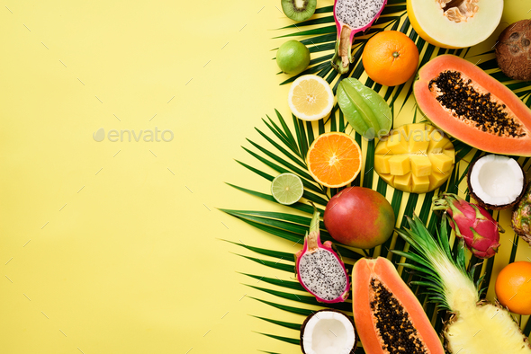 Exotic fruits and tropical palm leaves on pastel yellow background - papaya, mango, pineapple - Stock Photo - Images