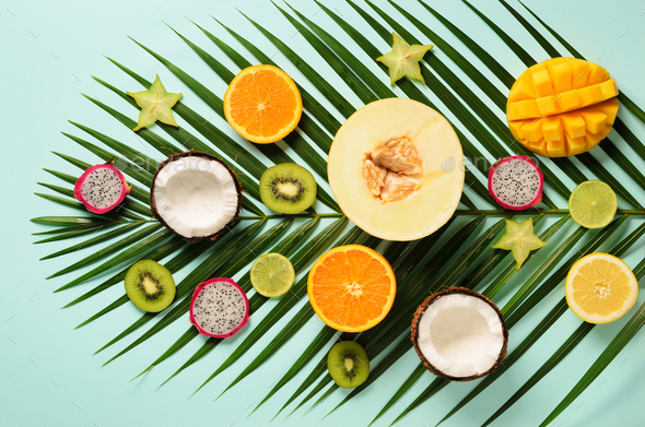 Exotic fruits and tropical palm leaves on pastel turquoise background - papaya, mango, pineapple - Stock Photo - Images