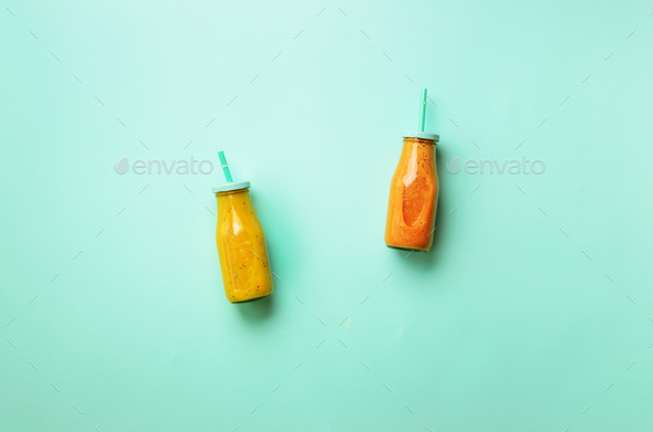 Fresh orange, banana, pineapple, mango smoothies and juicy fruits on blue background. Detox summer - Stock Photo - Images