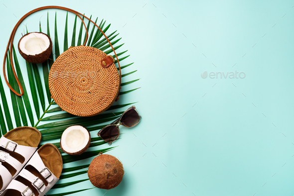 Stylish rattan bag, coconut, birkenstocks, palm branches, sunglasses on blue background. Banner. Top - Stock Photo - Images