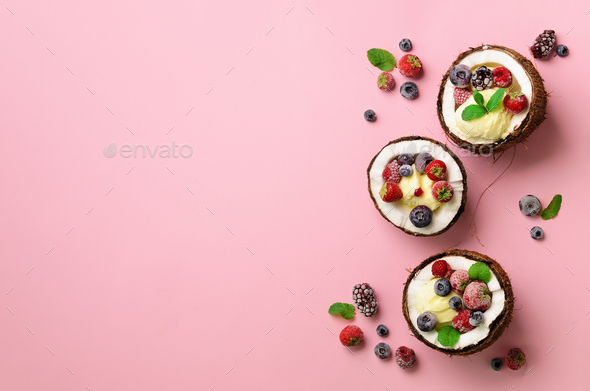 Coconut ice cream with fresh berries in coconuts halves on pink background with copy space. Top View - Stock Photo - Images