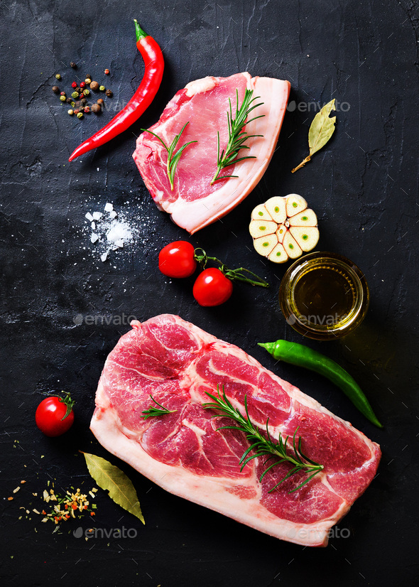 Raw fresh meat steak with cherry tomatoes, hot pepper, garlic, oil and herbs on dark stone, concrete - Stock Photo - Images
