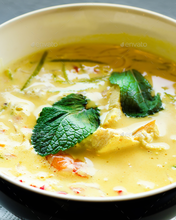 Spicy coconut milk cream soup curry with chiken, tiger prawns, long soy noodles, bean sprouts, lime - Stock Photo - Images