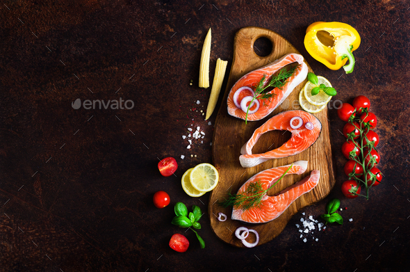 Raw salmon steaks, aromatic herbs, onion, lemon, salt and fresh vegetables for cooking on wooden - Stock Photo - Images