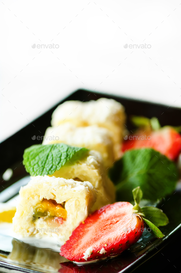 White sweet roll with kiwi, peaches, strawberries, mint. Serverd with almond peach and chocolate - Stock Photo - Images