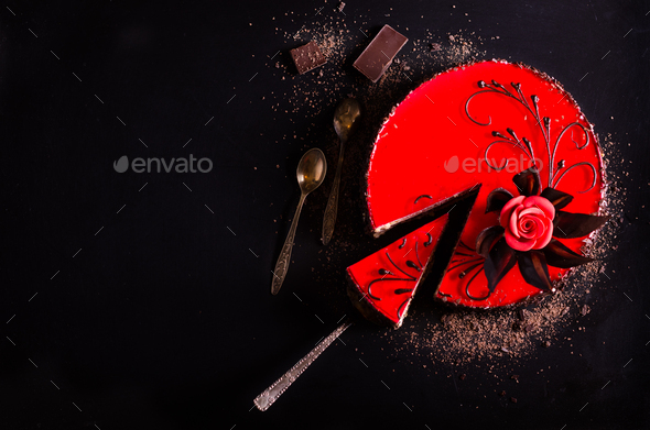 Red cake with rose, chocolate flower, on dark background. Free space for your text. Selective focus
