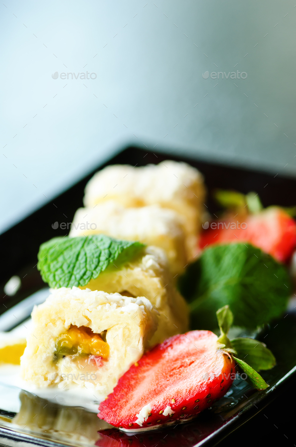 White sweet roll with kiwi, peaches, strawberries, mint. Serverd with almond peach and chocolate - Stock Photo - Images