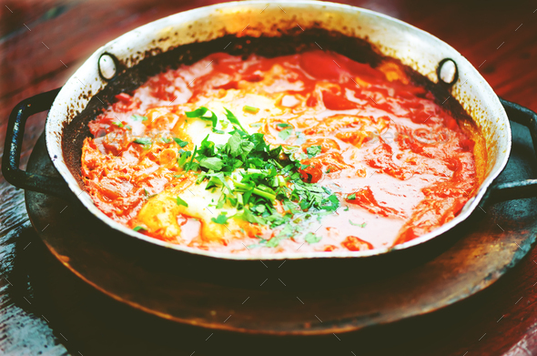 Shakshuka. Traditional jewish food and middle eastern cuisine recipe. Fried eggs, tomatoes, bell - Stock Photo - Images