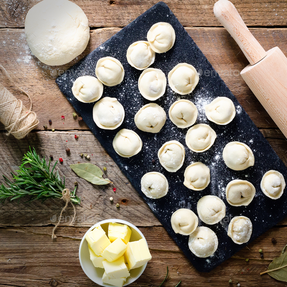 Preparing, cooking, making homemade ravioli, pelmeni or dumplings with meat on wooden table top view - Stock Photo - Images