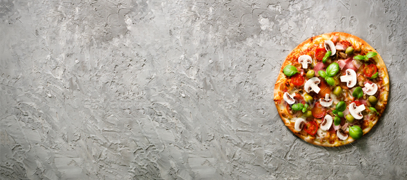 Fresh italian pizza with mushrooms, ham, tomatoes, cheese, olive, basil on grey concrete background - Stock Photo - Images