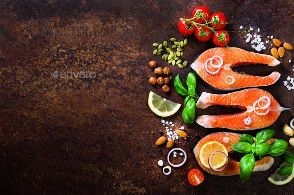 Raw salmon steaks, aromatic herbs, onion, lemon, salt and fresh vegetables for cooking on wooden - Stock Photo - Images