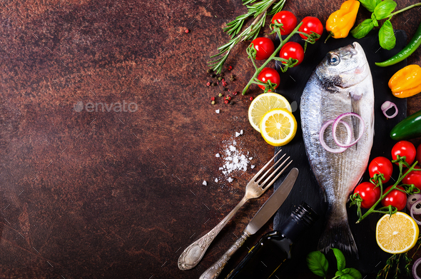 Dorada, fresh fish with vegetable, lemon, herbs, onion, paprika, cherry tomatoes, onion, salton dark - Stock Photo - Images