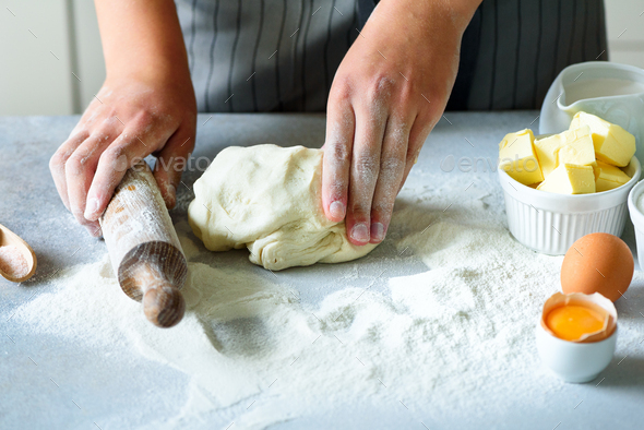 Female hands kneading dough, baking background. Cooking ingredients - eggs, flour, sugar, butter - Stock Photo - Images