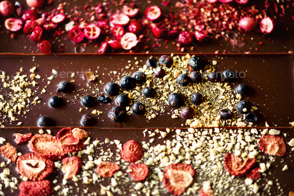 Handmade chocolate bars with dried cranberries, raspberries and pistachios, strawberries, nuts. Dark