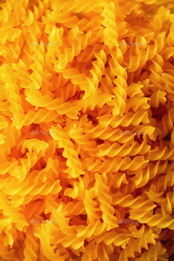 Fusilli noodles background, macaroni texture. Uncooked gluten free pasta from blend of corn and rice