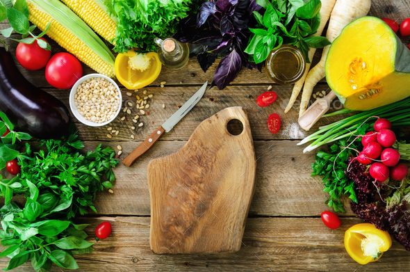 Vegetables on wooden background. Herbs, basil, onion, pumpkin, pine nuts, tomatoes, corn, radish - Stock Photo - Images