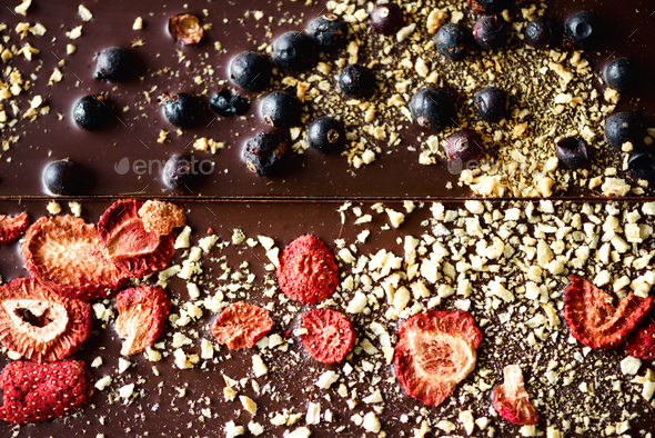 Handmade chocolate bars with dried cranberries, raspberries and pistachios, strawberries, nuts. Dark